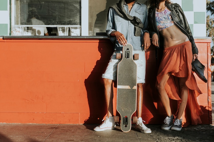 Photo young slim couple posing with a longboard