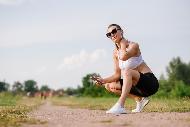 Молодая стройная женщина занимается спортом на открытом воздухе в парке в солнечный день