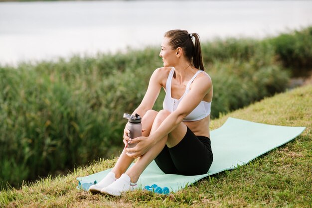 Young slim fit woman doing sport exercise outdoors in the park at the sunny day