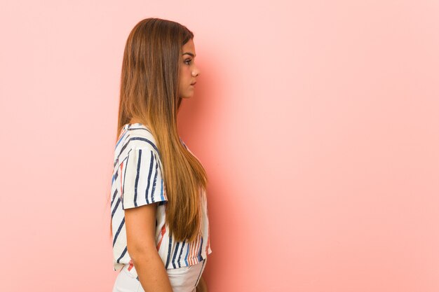 young slim woman gazing left, sideways pose.