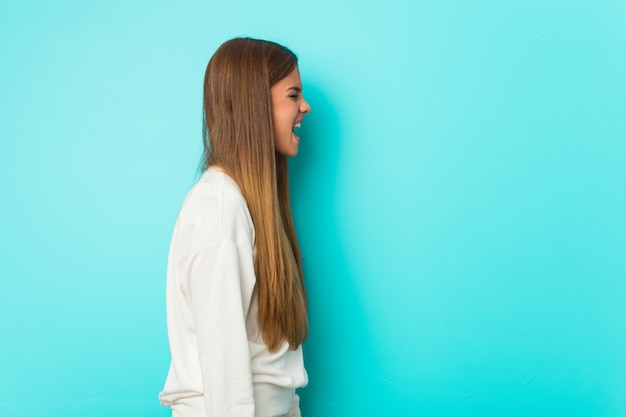 Young slim woman shouting towards a copy space