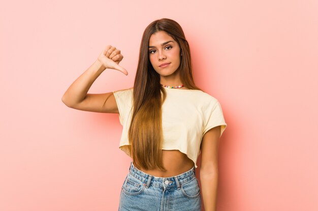 Young slim woman showing a dislike gesture, thumbs down