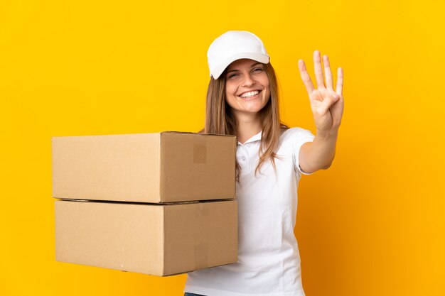 Young slovak delivery woman isolated on yellow wall happy and counting four with fingers