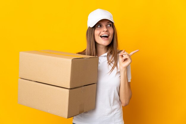 Young Slovak delivery woman isolated on yellow wall intending to realizes the solution while lifting a finger up