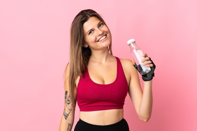 Young slovak woman isolated on pink  with sports water bottle