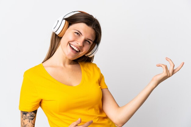 Young slovak woman isolated on white background listening music and doing guitar gesture