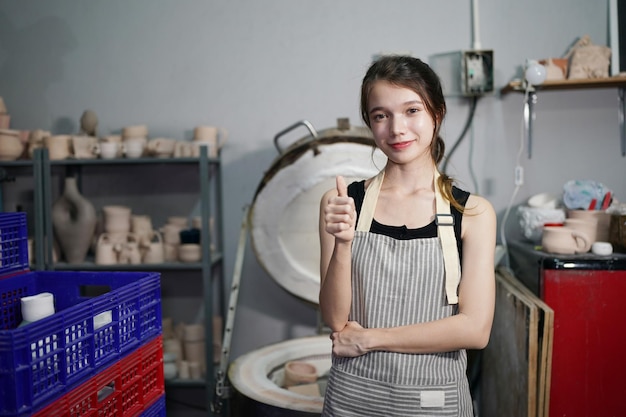 Young small business entrepreneur female with ceramics at the\
pottery workshop warehouse