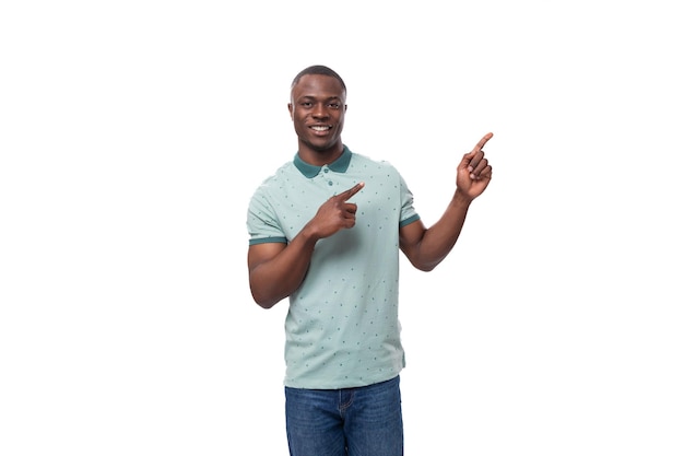 Молодой умный американец, одетый в мятную футболку, рассказывает новости и показывает пальцем