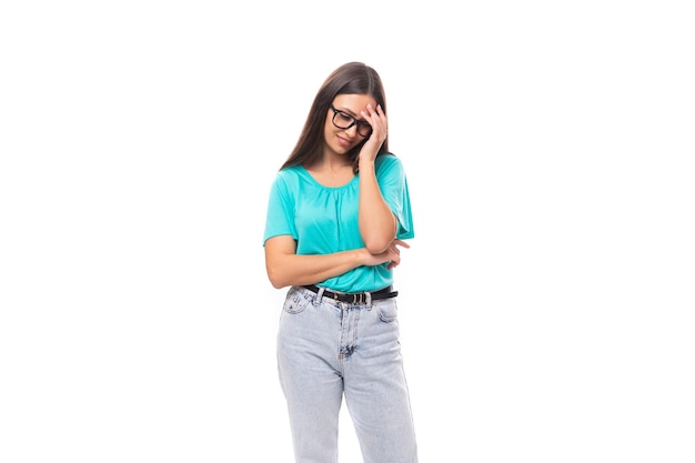 Young smart caucasian female model in glasses with black silky smooth hair dressed in a blue tshirt