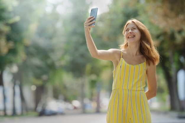 그녀의 휴대 전화는 selfie를 복용 젊은 스마트 웃는 여자.