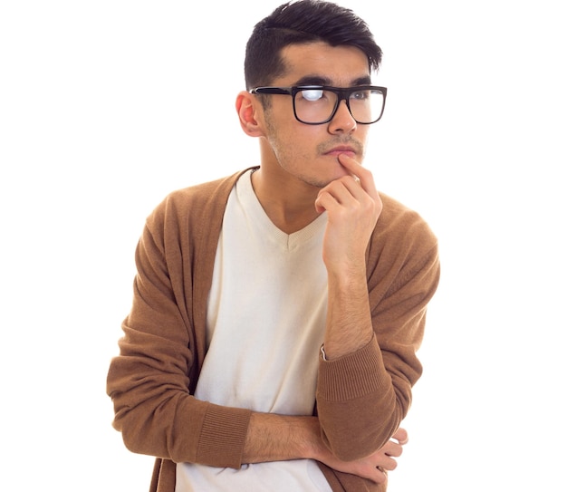 Young smartlooking man with black hair in white Tshirt brown cardigan with black glasses