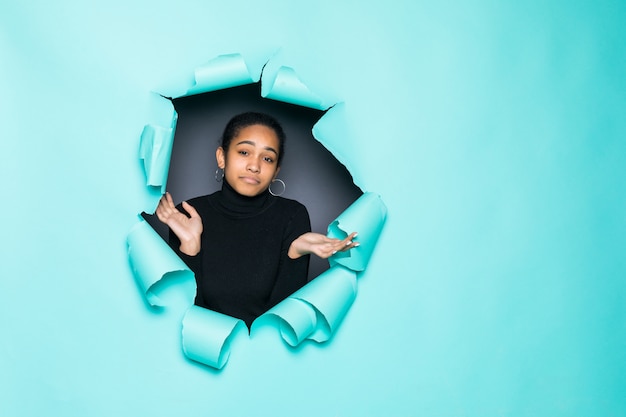 Photo young smile latin woman posing from green paper hole