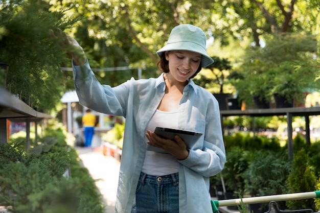 Photo young smiley woman working in a greenhouse