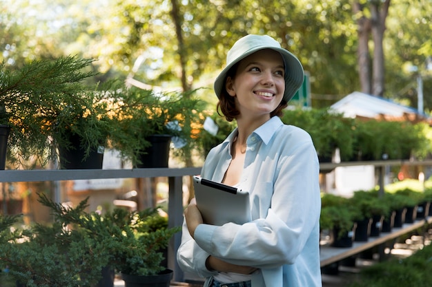 Young smiley woman working in a greenhouse