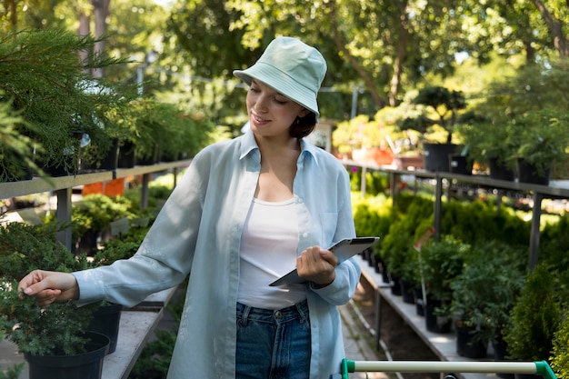 Photo young smiley woman working in a greenhouse