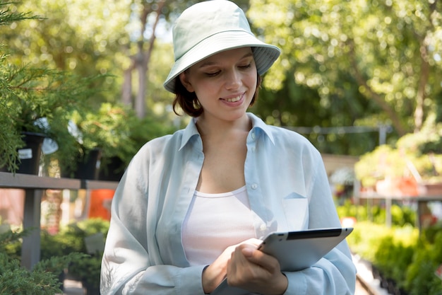 Young smiley woman working in a greenhouse