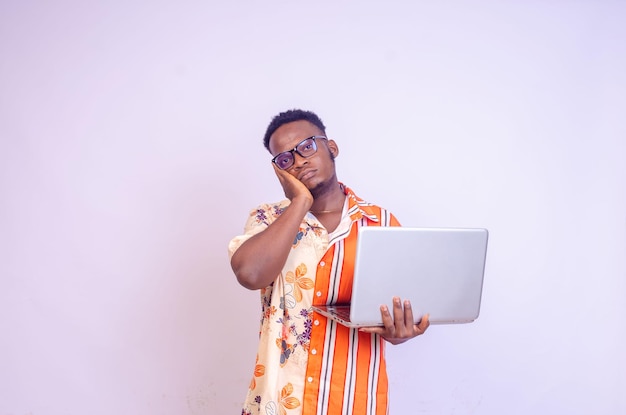 Young smiling african american man standing and using laptop computer isolated over white background