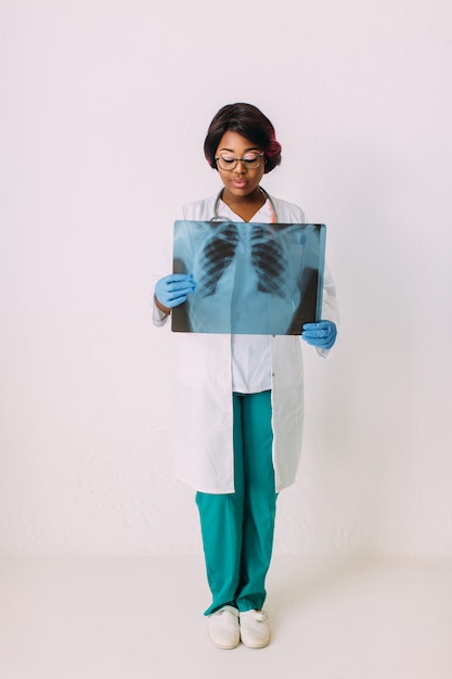 환자의 엑스레이 들고 의료 옷에 젊은 웃는 아프리카 계 미국인 여자 의사