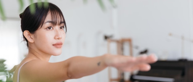 Virabhadrasana 2 운동을 하 고 요가 연습 웃는 매력적인 스포티 한 아시아 여자.