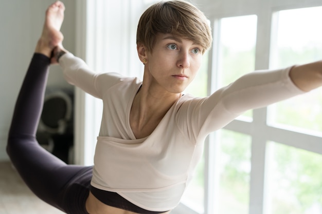 Young smiling attractive woman practicing yoga