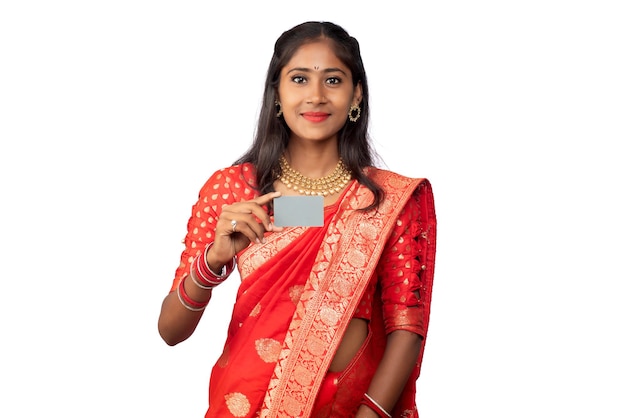 Young smiling beautiful girl posing with a credit or debit card on a white background