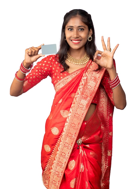 Young smiling beautiful girl posing with a credit or debit card on a white background