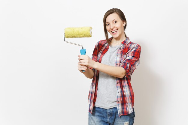 Young smiling beautiful woman in casual clothes holding paint roller for wall painting isolated on white background. Instruments, accessories, tools for renovation apartment room. Repair home concept.