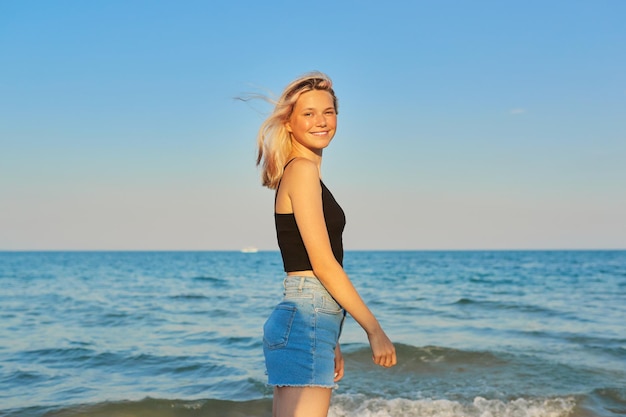 Молодая улыбающаяся блондинка-модель отдыхает и отдыхает на берегу моря