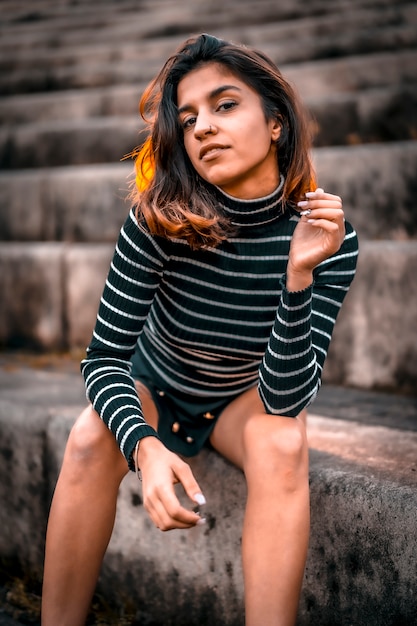 A young smiling brunette sitting on a ladder in a Lifestyle session