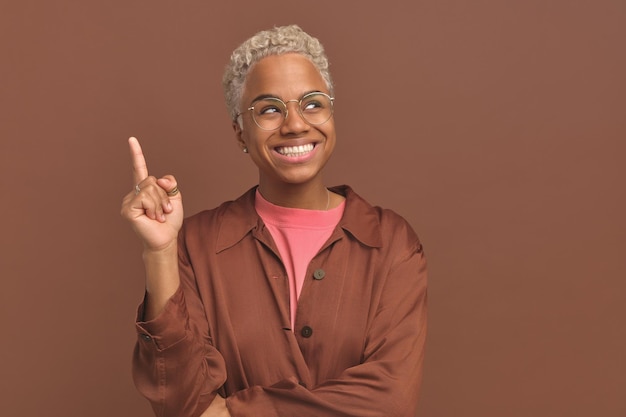 Young smiling casual african american woman student in glasses raises finger