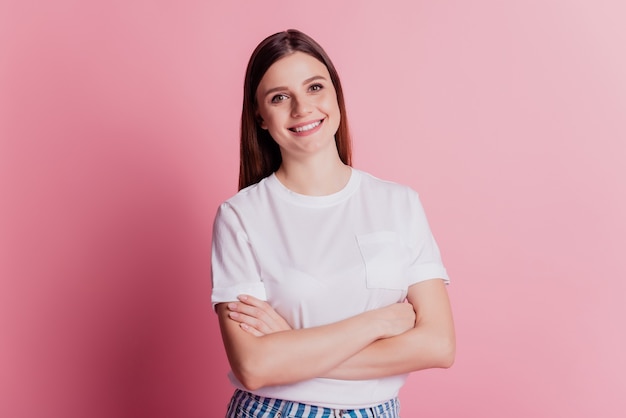 Young smiling cheerful girl look at camera folded arms shiny white smile on pink wall