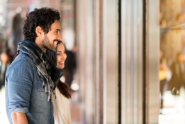 Photo young smiling couple shopping in an urban street