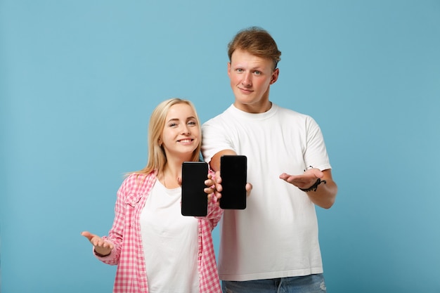 Young smiling couple two friends man and woman  in white pink t-shirts posing 