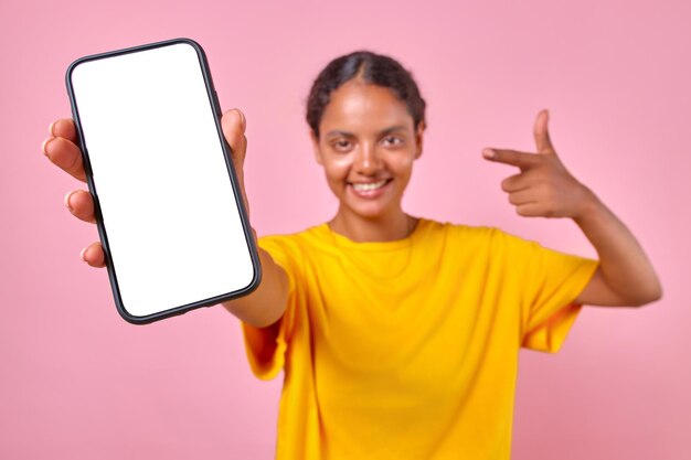 Young smiling cute indian woman teenager holds smartphone with white screen