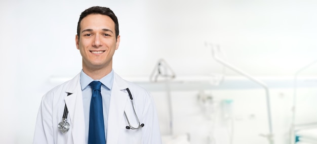 Foto giovane medico sorridente in una stanza d'ospedale