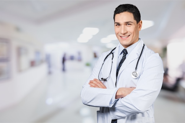 Young smiling doctor portrait on blurred hospital background