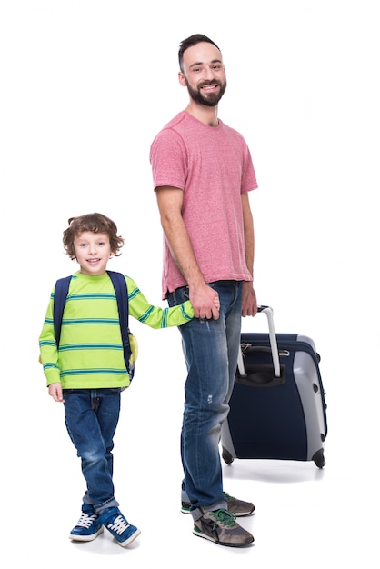 Young smiling father and his son with luggage.