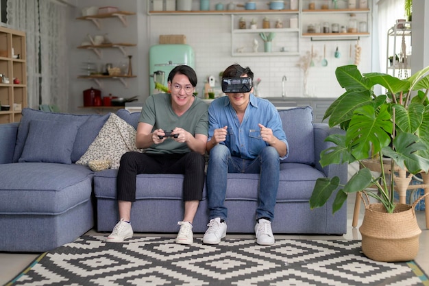 Young smiling gay couple playing video games in the living room at home LGBTQ and diversity