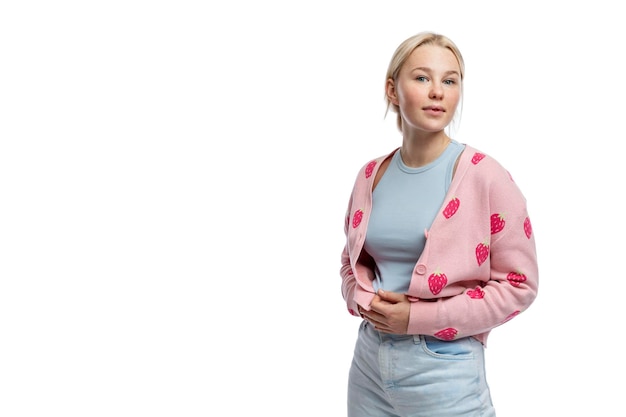Young smiling girl A cute blonde with freckles and a braid in jeans and a romantic pink jacket Purity and youth Isolated on a white background Space for text