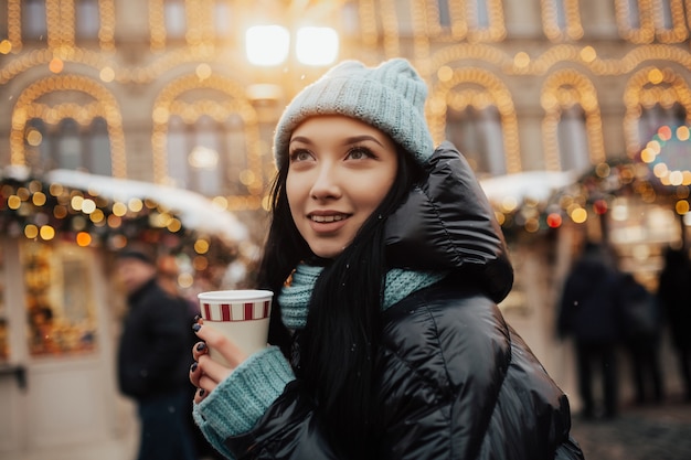 クリスマスマーケットで冬の若い笑顔の女の子