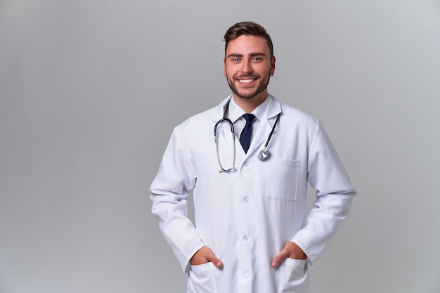 Young smiling handsome caucasian doctor on white background