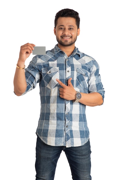 Young smiling handsome man posing with a credit or debit card on white background