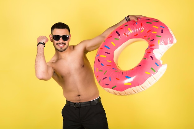 Young smiling happy tourist man hold inflatable ring