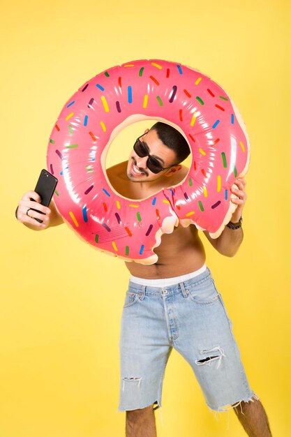 Young smiling happy tourist man hold inflatable ring