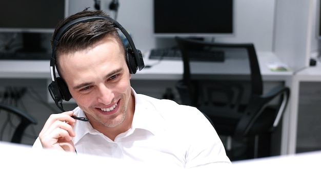 young smiling male call centre operator doing his job with a headset