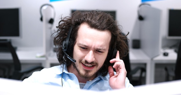 young smiling male call centre operator doing his job with a headset