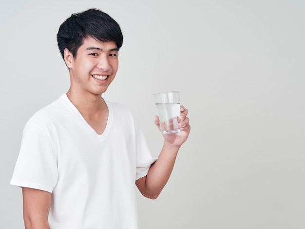 Young smiling man holding water glass