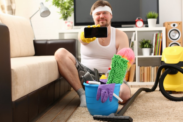 A young smiling man holds a smartphone