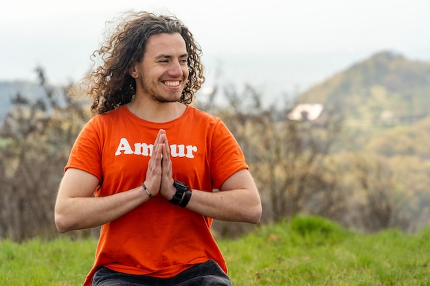 Young smiling man sitting on the mountain Relax and calm