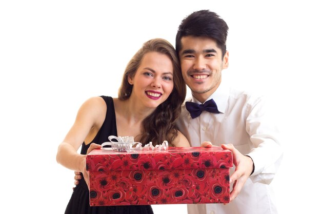 Young smiling man with black hair and young pretty woman with long blond hair showing red present